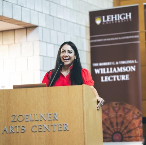 Hajar Yazdiha speaks on stage at Zoellner Arts Center.